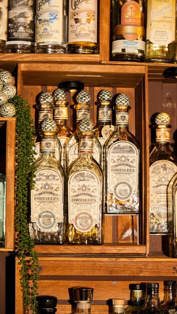 Fortaleza tequila in a lit wooden crate on La Licor's agave and rum back bar